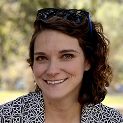Stacy Branham, a white middle-aged woman with short, asymmetrical, wavy brown hair and a big smile.