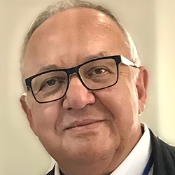 Georgios Kouroupetroglou, a white man with sparsely gray hair and blue blazer over a white shirt