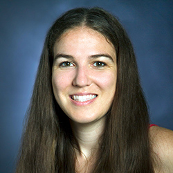 A professional headshot of Kyle Rector, a white woman with brown hair and eyes